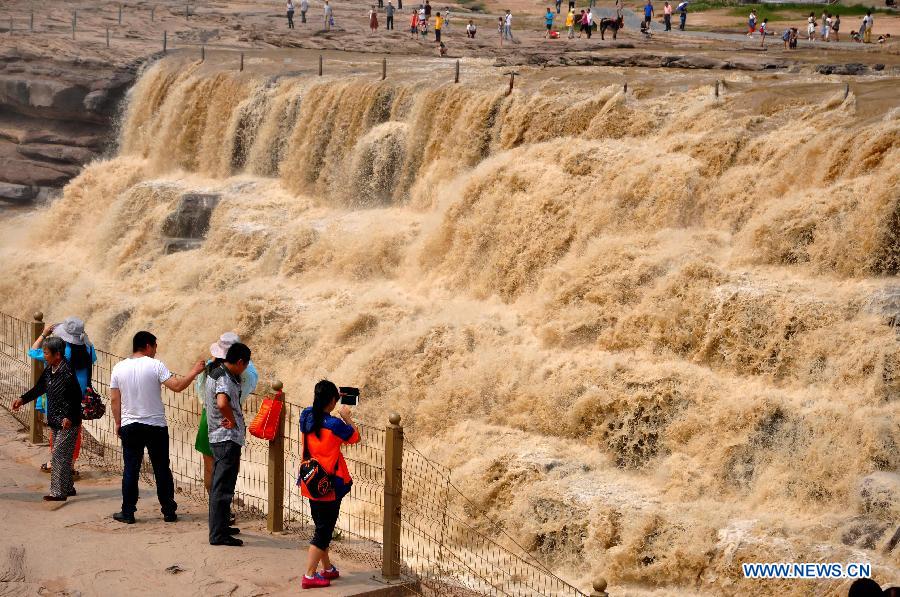 Tourist take photos of Hukou Waterfall on the Yellow River in Linfen, north China's Shanxi Province, July 10, 2015.