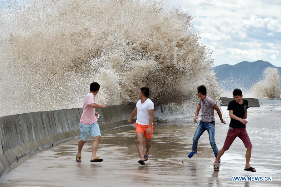 People dodge waves in Sansha Township of Xiapu, southeast China's Fujian Province, July 10, 2015. China is on highest alert as super typhoon Chan-Hom approaches the eastern coast at high speeds.