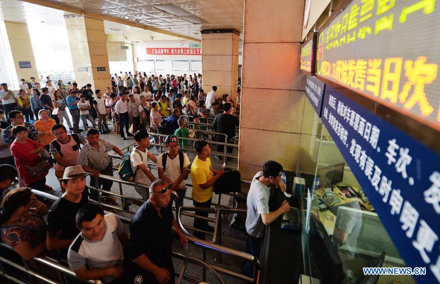 Passengers queue up to buy tickets at Lanzhou Railway Station in Lanzhou, capital of northwest China's Gansu Province, July 13, 2015.