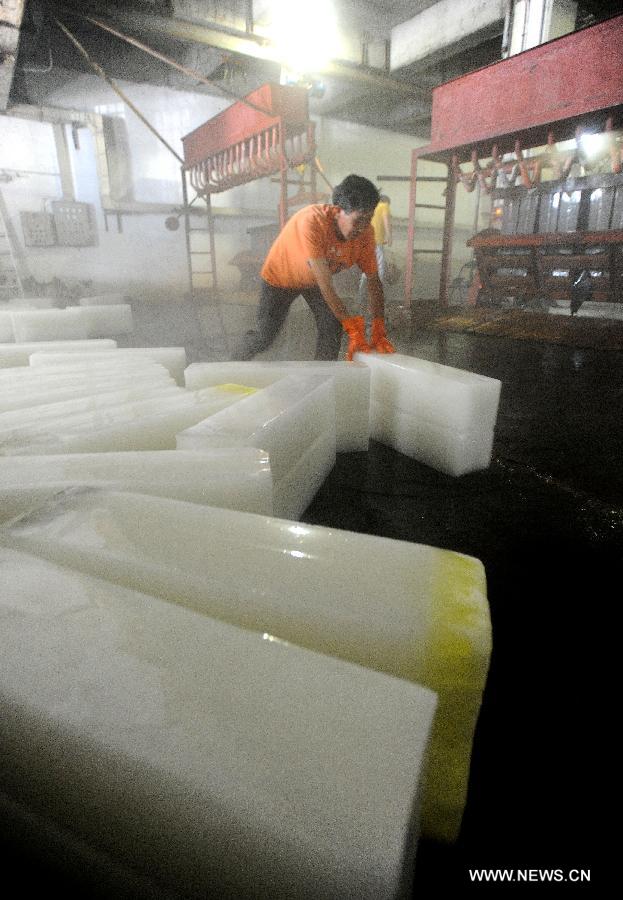 Workers produce ice bricks at a plant in Suzhou City, east China's Jiangsu Province, July 14, 2015. Ice bricks sold well as the temperature climbed up high in Suzhou. 