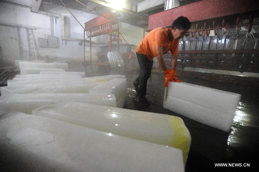 Workers produce ice bricks at a plant in Suzhou City, east China's Jiangsu Province, July 14, 2015. Ice bricks sold well as the temperature climbed up high in Suzhou. 