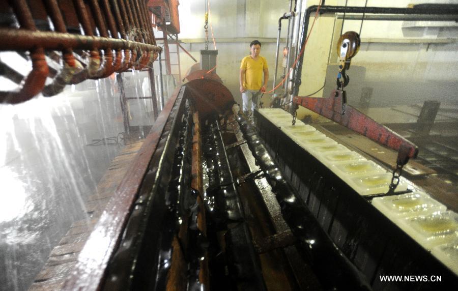 Workers produce ice bricks at a plant in Suzhou City, east China's Jiangsu Province, July 14, 2015. Ice bricks sold well as the temperature climbed up high in Suzhou. 