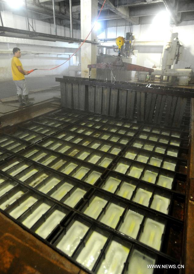 Workers produce ice bricks at a plant in Suzhou City, east China's Jiangsu Province, July 14, 2015. Ice bricks sold well as the temperature climbed up high in Suzhou. 