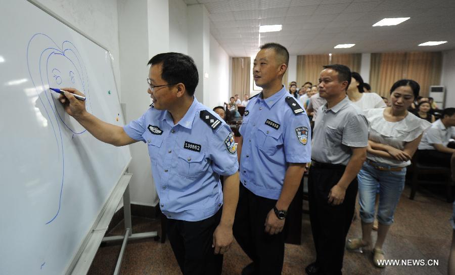 Students draw a woman portrait to learn about social status difference of men and women at a training class on anti-domestic violence at the Hunan Police Academy in Changsha, capital of east China's Hunan Province, July 15, 2015.