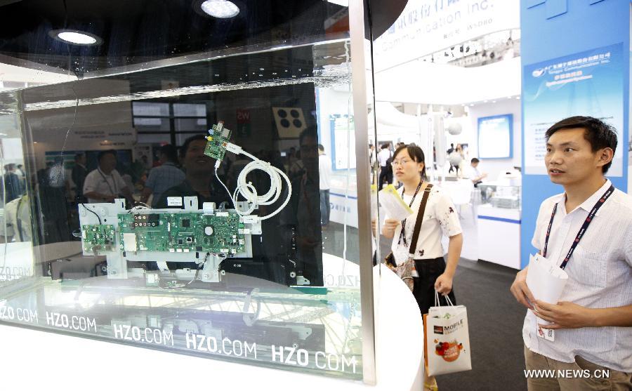 An LCD television working underwater attracts audience at the Mobile World Congress Shanghai launched in Shanghai, east China, July 15, 2015.