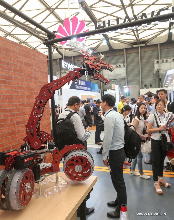 Spectators watch a robot at Mobile World Congress (MWC) with the theme of Mobile Infinity in Shanghai, east China, July 15, 2015. 