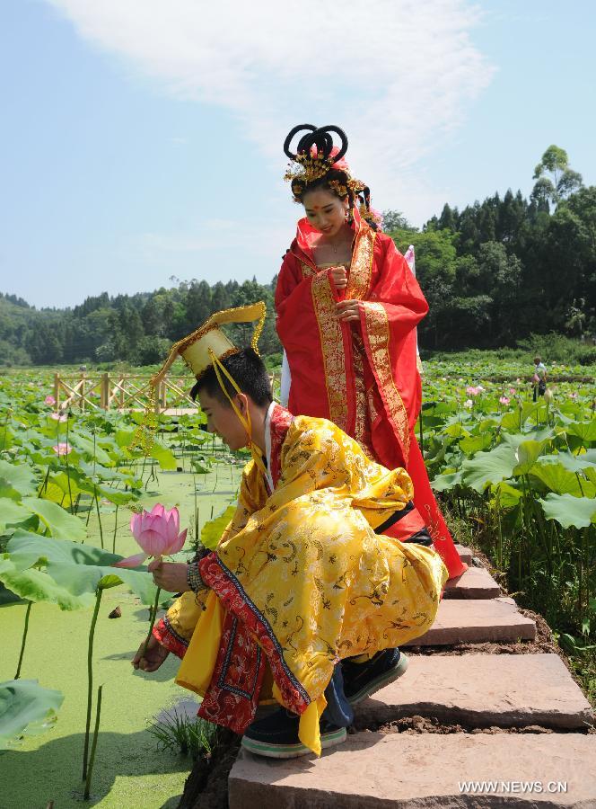 Actors dressed as an ancient imperial family are seen at a local lotus festival at Yangling Village in Neijiang City, southwest China's Sichuan Province, July 16, 2015. 