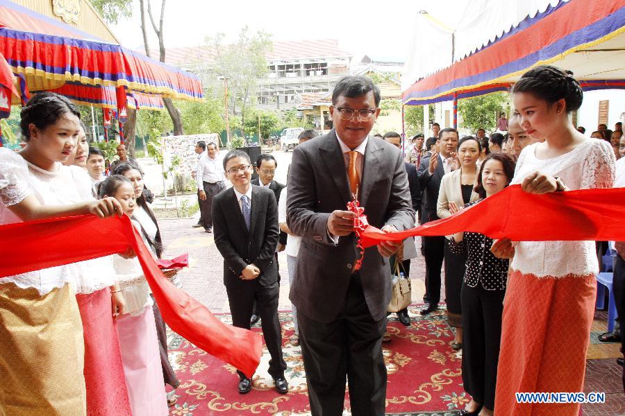 Cambodian Education Minister Hang Chuon Naron (C) cuts the ribbon to inaugurate a China-funded school building in Phnom Penh, Cambodia, July 16, 2015.