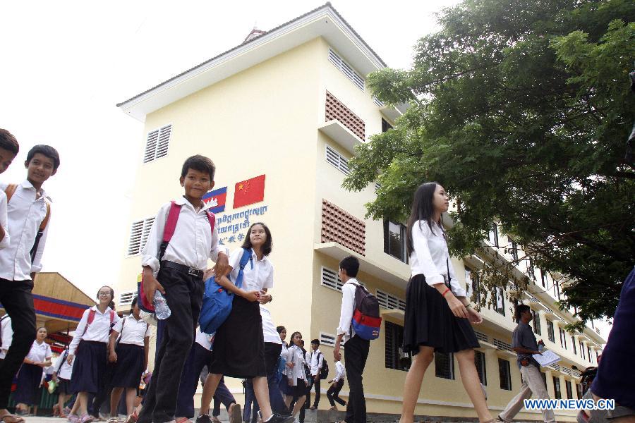 Cambodian students walk past a China-funded school building in Phnom Penh, Cambodia, July 16, 2015. 