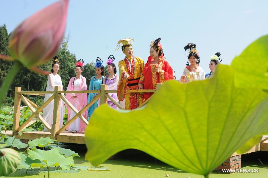 Actors dressed as an ancient imperial family are seen at a local lotus festival at Yangling Village in Neijiang City, southwest China's Sichuan Province, July 16, 2015. 