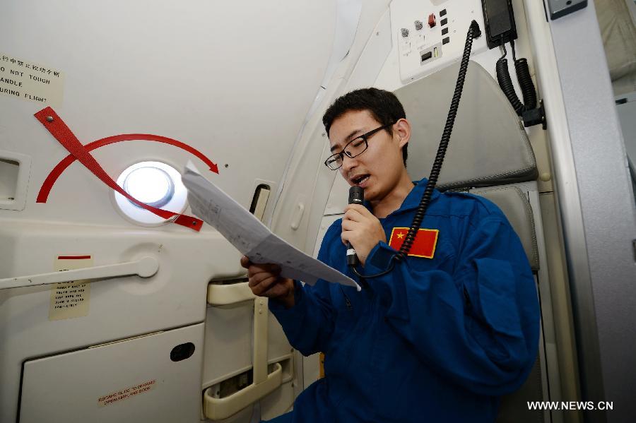 Engineer Jin Xing introduces the ARJ21-700 jet to passengers during a demonstration flight in Xi'an, capital city of northwest China's Shaanxi Province, July 17, 2015. 