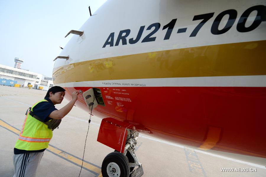A ground crew member checks the ARJ21-700 jet after a demonstration flight in Xi'an, capital city of northwest China's Shaanxi Province, July 17, 2015. 