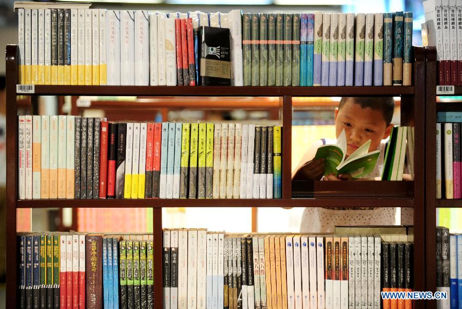 Readers read at a bookstore in Shenyang, capital of northeast China's Liaoning Province, July 16, 2015. Bookstores with cool and comfortable environment have provided a good place for people to read during the days when heat wave hit Shenyang. (Xinhua/Zhang Wenkui) 