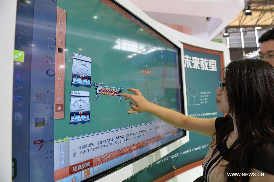 A visitor experiences a 'touching blackboard' during the Mobile World Congress Shanghai in Shanghai, east China, July 17, 2015. 