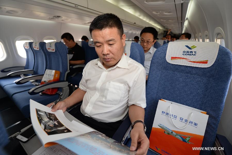 Passengers experience a demonstration flight of the ARJ21-700 jet in Xi'an, capital city of northwest China's Shaanxi Province, July 17, 2015. 