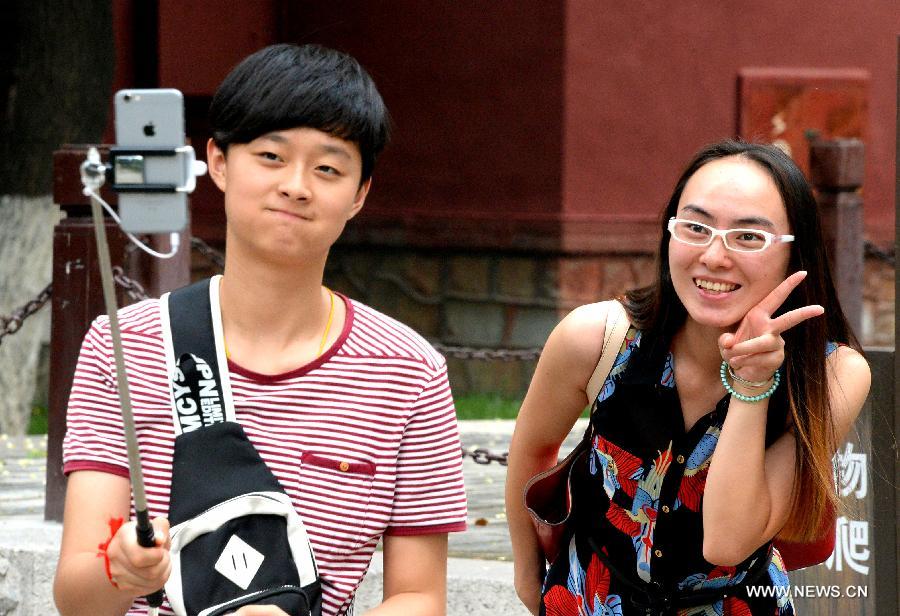 Tourists take photo in Dai Temple (Temple of Mount Tai) at the foot of Mount Tai in Tai'an, east China's Shandong Province, July 17, 2015.