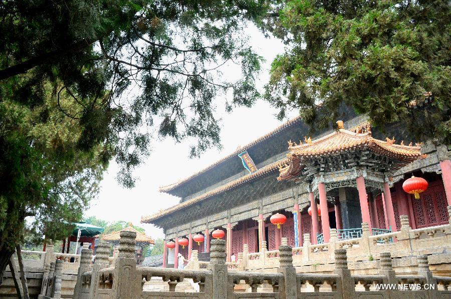 Tourists appreciate Tiankuang Hall, the main structure of Dai Temple at the foot of Mount Tai in Tai'an, east China's Shandong Province, July 17, 2015.