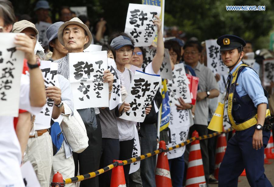 People hold placards reading 'Abe politics is unforgivable' during a rally in front of the parliament building in Tokyo, Japan, July 18, 2015. About five thousand people took part in the demonstration.