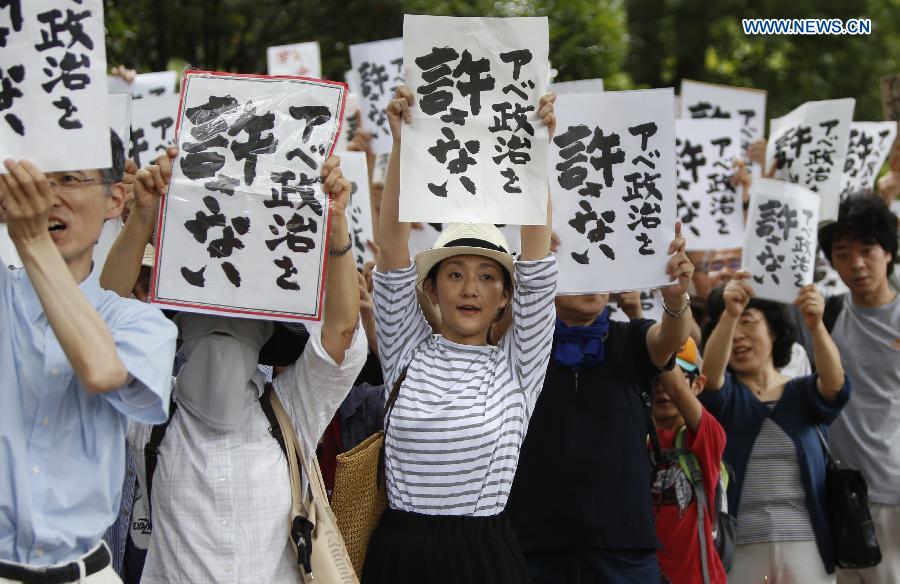 People hold placards reading 'Abe politics is unforgivable' during a rally in front of the parliament building in Tokyo, Japan, July 18, 2015. About five thousand people took part in the demonstration.