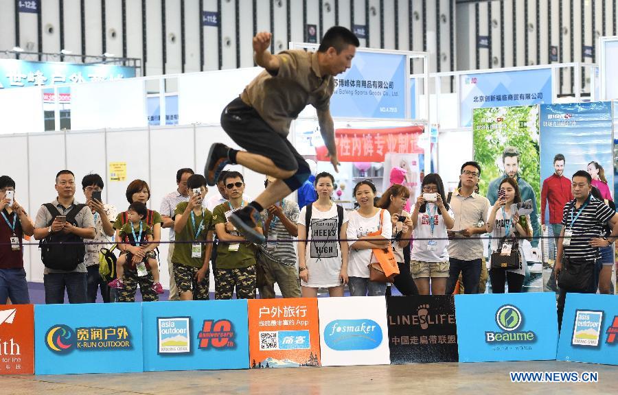 A sports enthusiast performs during the Asia Outdoor Trade Show 2015 in Nanjing, capital of east China's Jiangsu Province, July 23, 2015.