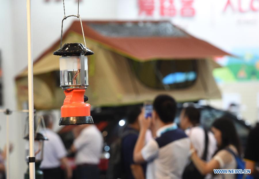 People visit a vehicle awning stand during the Asia Outdoor Trade Show 2015 in Nanjing, capital of east China's Jiangsu Province, July 23, 2015. 