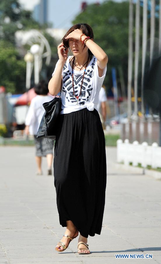 A woman walks on a street in Yinchuan, capital of northwest China's Ningxia Hui Autonomous Region, July 24, 2015. 