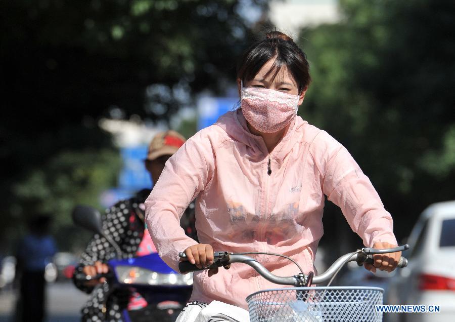 A woman rides on a street in Yinchuan, capital of northwest China's Ningxia Hui Autonomous Region, July 24, 2015. 