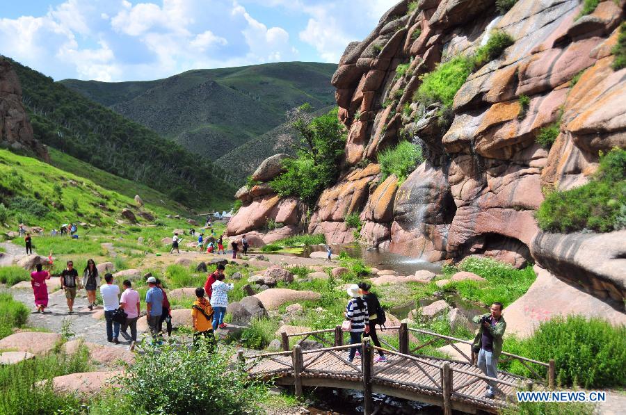 Tourists enjoy the scenery of the grassland near Ulanqab City, north China's Inner Mongolia Autonomous Region, July 24, 2015. 