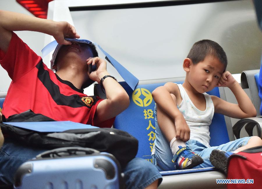 Passengers wait for boarding train at Beijing South Railway Station in Beijing, July 24, 2015. 