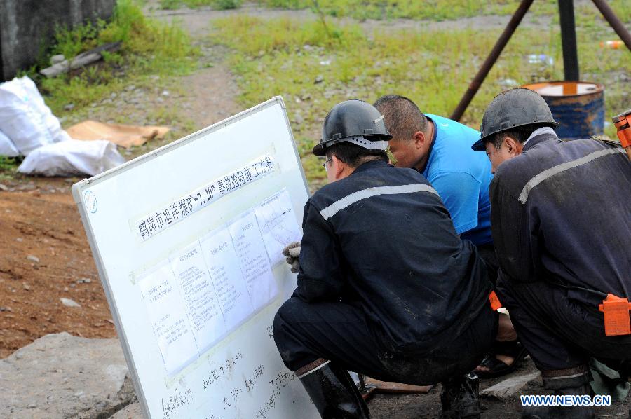 Rescuers discuss working plans at Xuxiang Colliery in Hegang City, northeast China's Heilongjiang Province, July 24, 2015. 