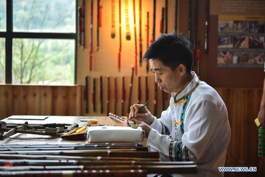 A craftsman shows processes of making Yuping vertical flute during a culture expo in Guiyang, capital of southwest China's Guizhou Province, July 24, 2015.