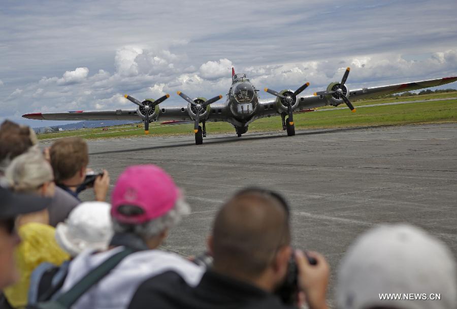 Crowds watch a Boeing B-17 heavy bomber aircraft performing a flight demonstration at the Boundary Bay air show in Delta, Canada, July 25, 2015. 