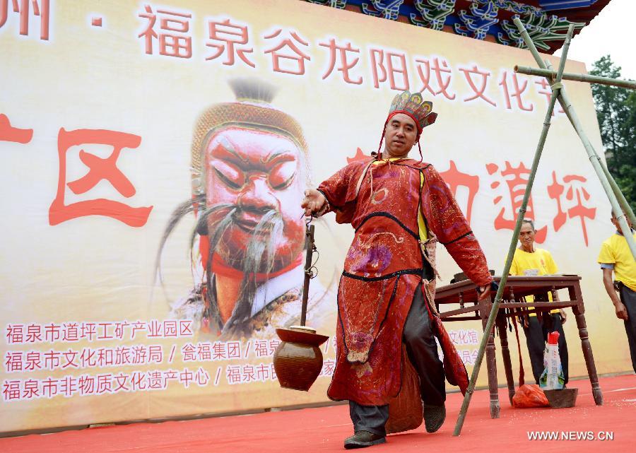 An inheritor of Yang opera performs at a fair in Gulong village, southwest China's Guizhou Province, July 25, 2015. Yang opera, a branch of Nuo opera, is listed in the provincial intangible cultural heritages.(Xinhua/Wu Rubo)