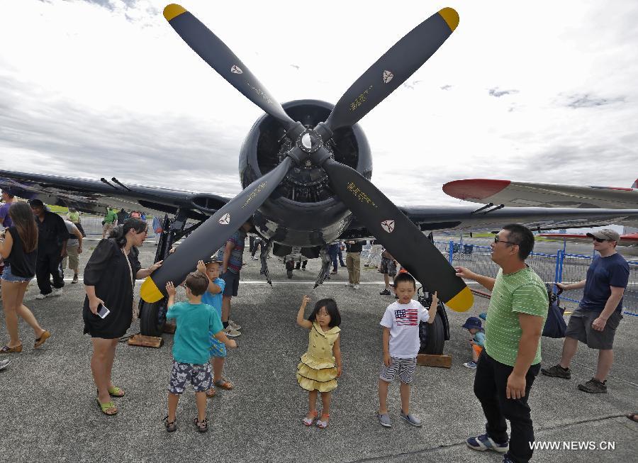 Visitors watch a vintage aircraft on display at the Boundary Bay air show in Delta, Canada, July 25, 2015. 