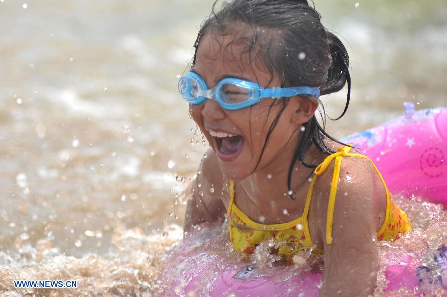 A girl plays in the sea at a beach in Qingdao, east China's Shandong Province, July 27, 2015.