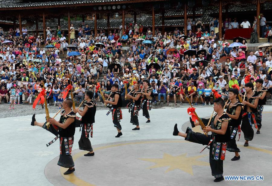 Villagers of Miao ethnic group perform lusheng dance at Xijiang Qianhu Miao Village in Leishan County, southwest China's Guizhou Province, July 29, 2015. The village with more than 1,000 wooden stilted houses attracted a large number of tourists in the summer travel season. (Xinhua/Qiao Qiming) 