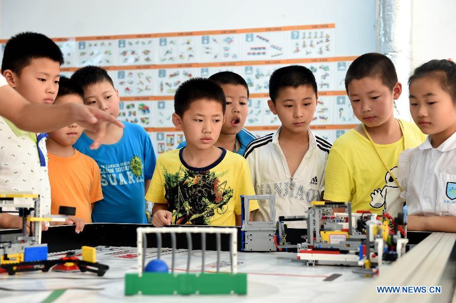 Members of an interest group at Furong primary school test a robot during a summer camp class in Hefei, capital of east China's Anhui Province, July 30, 2015. A robot class held in the Furong primary school of Hefei attracted many students during the summer vacation. (Xinhua/Liu Junxi) 