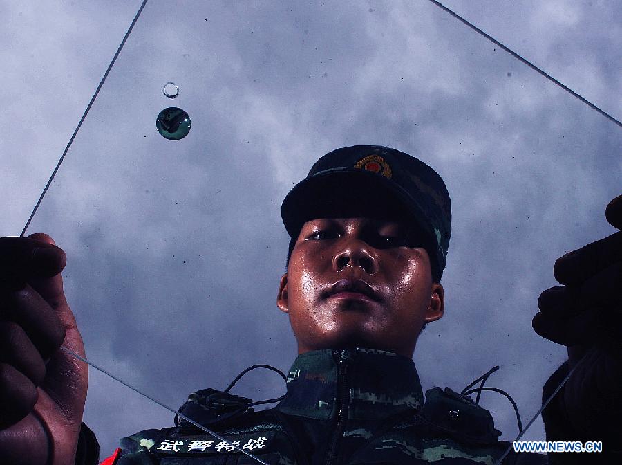 Xie Liuxiang, an Explosive Ordance Disposal(EDO) police, takes balance training in east China's Shanghai Municipality, July 30, 2015. EDO police of Shanghai armed police unit continued their training as the heat wave scorched Shanghai. (Xinhua/Chen Fei) 