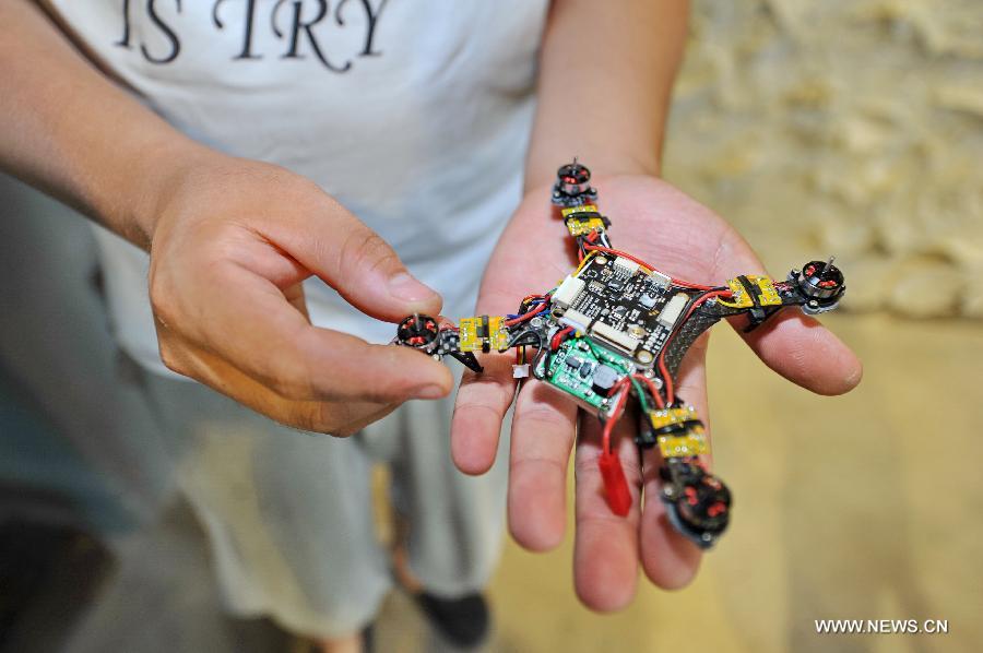 Gao Hua shows an automatic-tracking drone at the Baidu Pioneer Park in Changchun, capital of northeast China's Jilin Province, July 30, 2015. Graduated from Jilin University, Gao Hua and Hou Xiaoye are both enthusiasts in science and technology. Getting bored with average work, they founded their geek studio which undertakes innovation of gadgets such as 3D printers, drones and wearable virtual reality headsets that they believe can change people's everyday life. (Xinhua/Zhang Nan) 