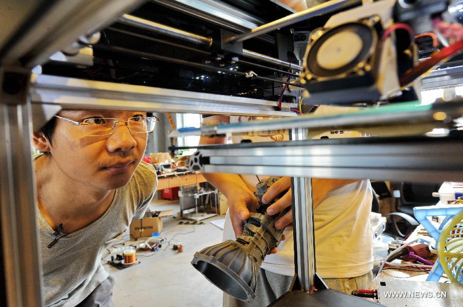 Hou Xiaoye checks a working 3D printer at the the Baidu Pioneer Park in Changchun, capital of northeast China's Jilin Province, July 30, 2015. Graduated from Jilin University, Gao Hua and Hou Xiaoye are both enthusiasts in science and technology. Getting bored with average work, they founded their geek studio which undertakes innovation of gadgets such as 3D printers, drones and wearable virtual reality headsets that they believe can change people's everyday life. (Xinhua/Zhang Nan) 