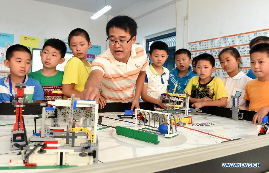 Members of an interest group at Furong primary school test a robot during a summer camp class in Hefei, capital of east China's Anhui Province, July 30, 2015. A robot class held in the Furong primary school of Hefei attracted many students during the summer vacation. (Xinhua/Liu Junxi) 