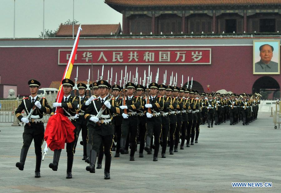 Soldiers salute during a national flag-raising ceremony at the Tian'anmen Square in Beijing, capital of China, Aug. 1, 2015. 