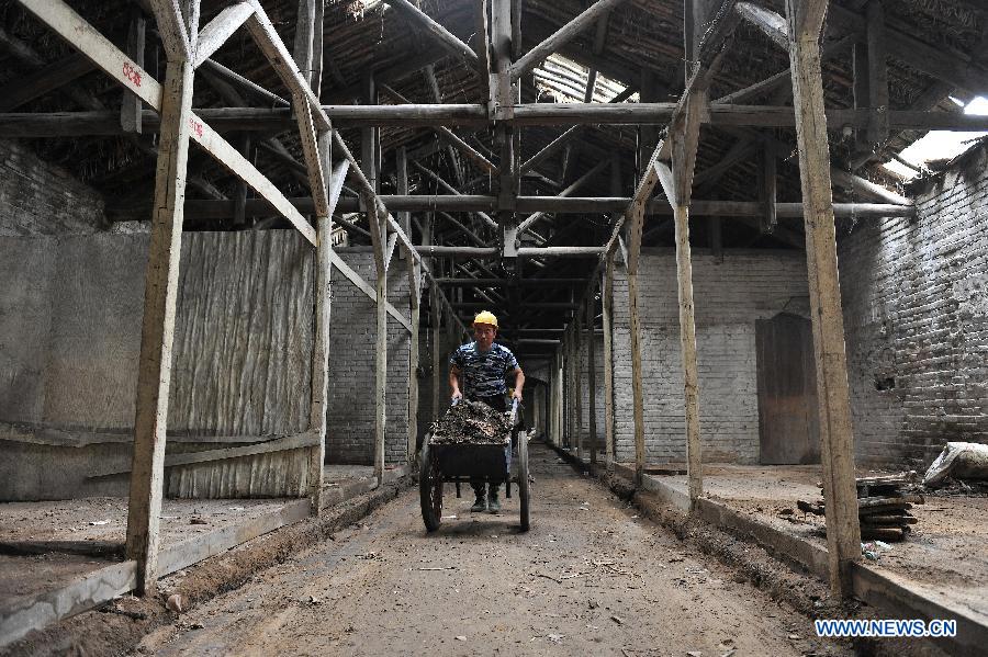 A worker clears rubbish at the site of a former concentration camp in Taiyuan, capital of north China's Shanxi Province, Aug. 3, 2015.