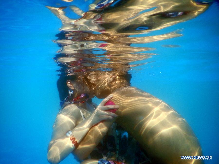 Participants take part in an underwater kissing contest in Wuhan, capital of central China's Hubei Province, Aug. 2, 2015. 