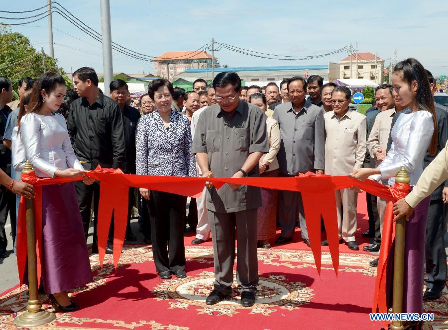 Cambodian Prime Minister Hun Sen (C) cuts the ribbon to inaugurate China-funded Takhmau Bridge in Kandal province, Cambodia, Aug. 3, 2015. 