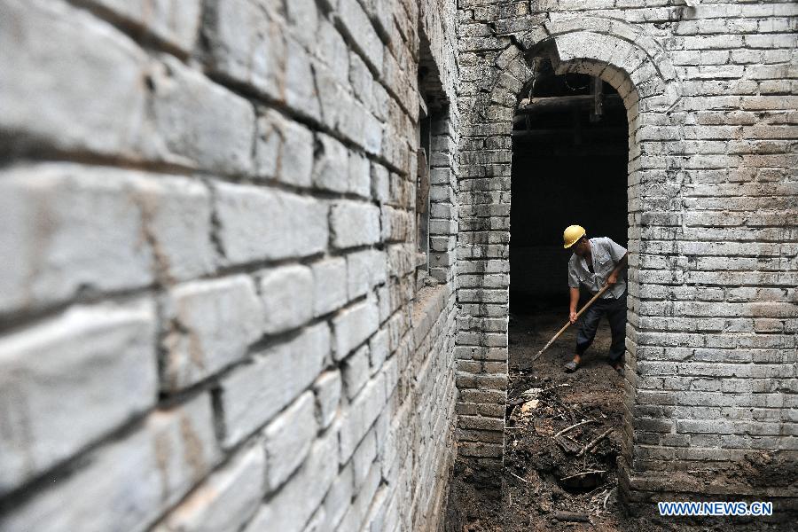 A worker clears rubbish at the site of a former concentration camp in Taiyuan, capital of north China's Shanxi Province, Aug. 3, 2015. 