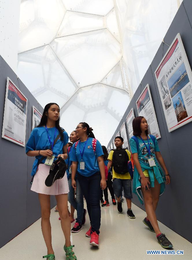 Youth visit a photo exhibition with the theme of 'Overseas Chinese and the Chinese People's War of Resistance against Japanese Aggression' at National Aquatics Center in Beijing, capital of China, Aug. 4, 2015. 