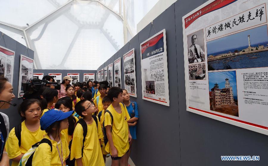 Youth visit a photo exhibition with the theme of 'Overseas Chinese and the Chinese People's War of Resistance against Japanese Aggression' at National Aquatics Center in Beijing, capital of China, Aug. 4, 2015.