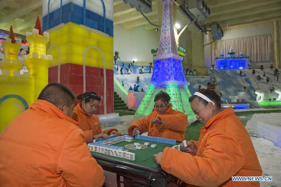 People wearing padded coats play mahjong in an icehouse at Foreigner's Street in Chongqing, southwest China, Aug. 4, 2015.
