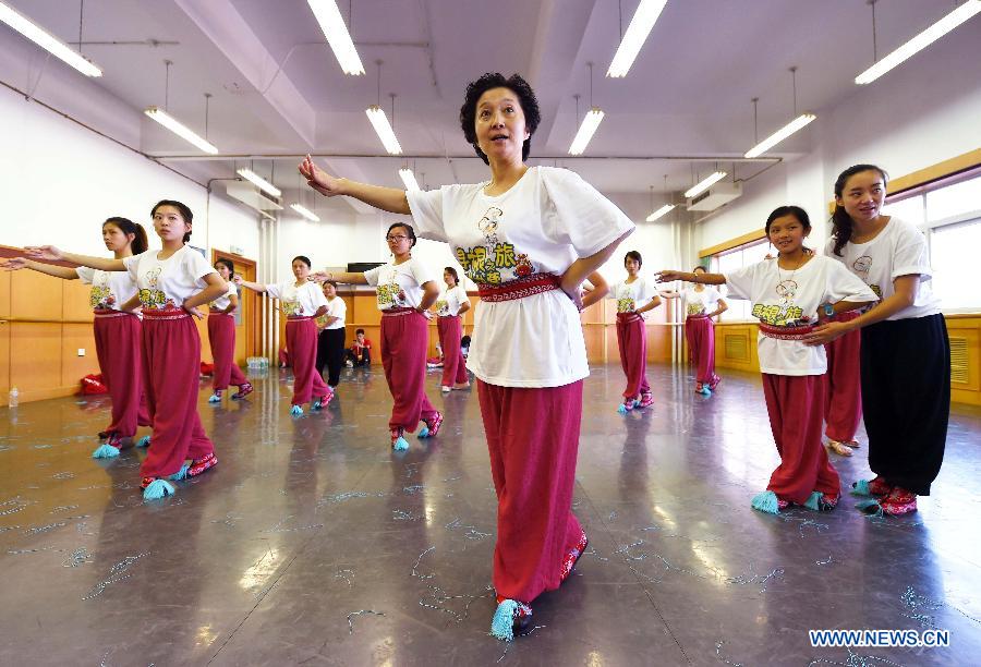 Youngsters learn the basic movements in traditional Chinese opera from the teachers in National Academy of Chinese Theatre Arts in Beijing, capital of China, Aug. 4, 2015.